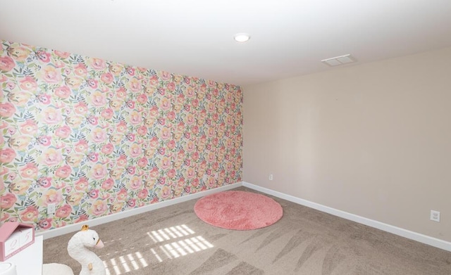 carpeted empty room with visible vents and baseboards