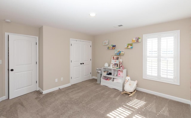 rec room with carpet floors, visible vents, and baseboards