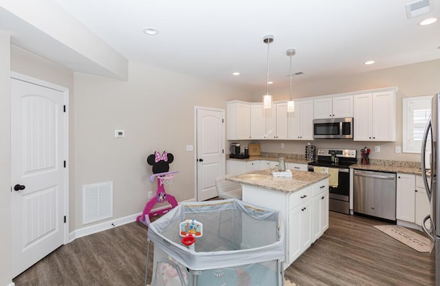 kitchen featuring white cabinetry, visible vents, stainless steel appliances, and wood finished floors