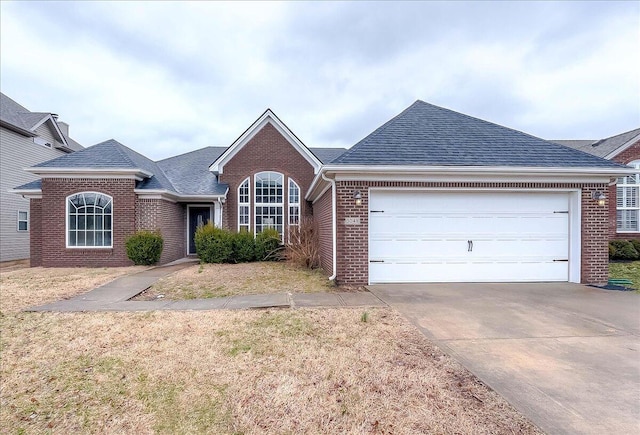 single story home with a garage, concrete driveway, brick siding, and a shingled roof