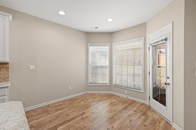 unfurnished dining area with plenty of natural light and baseboards