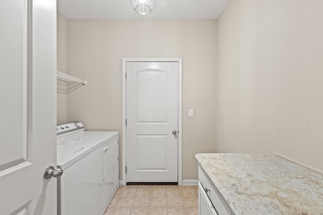 washroom featuring baseboards, cabinet space, and washing machine and clothes dryer