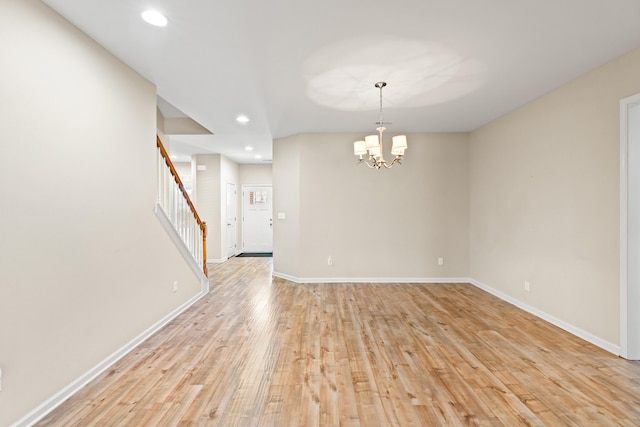 spare room with a chandelier, recessed lighting, baseboards, stairs, and light wood finished floors