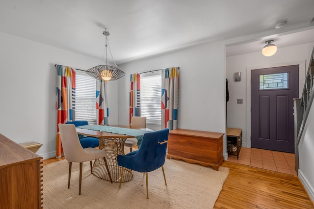 dining space with light wood-style flooring and baseboards