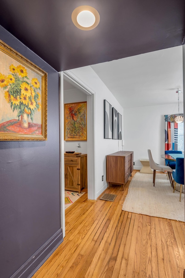 hall with baseboards and light wood-style floors