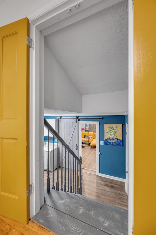 stairs with vaulted ceiling and wood finished floors