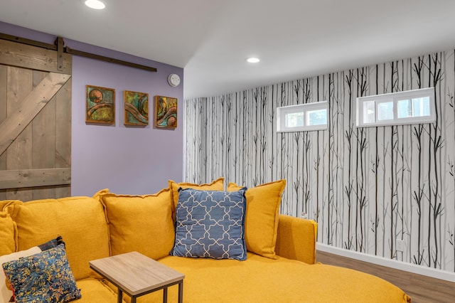 sitting room with baseboards, a barn door, wood finished floors, and recessed lighting