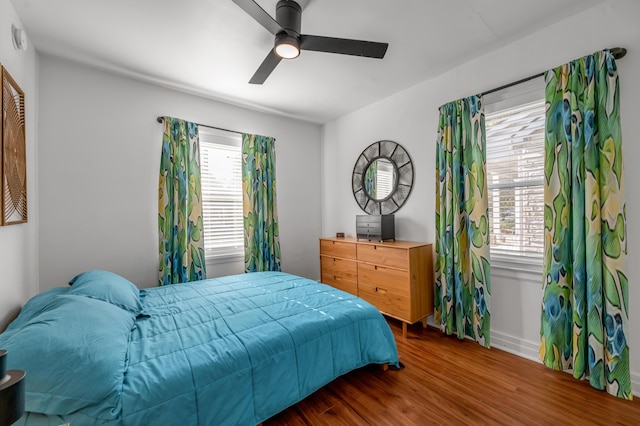 bedroom with dark wood-style floors and a ceiling fan