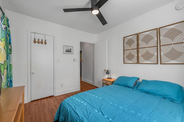 bedroom featuring dark wood-style floors, baseboards, and a ceiling fan