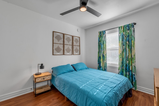 bedroom with wood finished floors, a ceiling fan, and baseboards