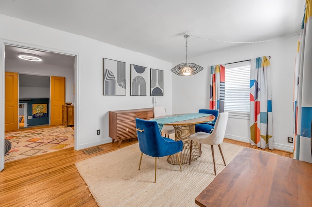 dining area with visible vents, baseboards, and wood finished floors