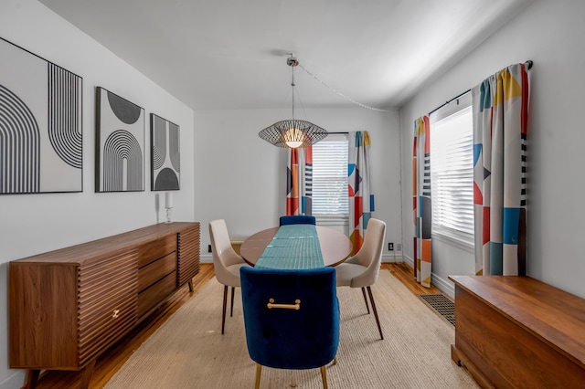 dining area featuring light wood-style floors and baseboards