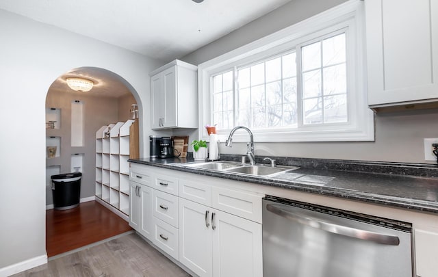 kitchen with dark countertops, dishwasher, and a sink