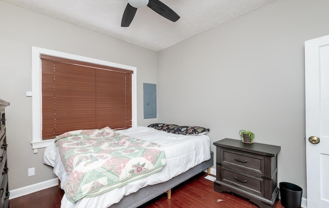 bedroom featuring dark wood-style floors, electric panel, baseboards, and a ceiling fan