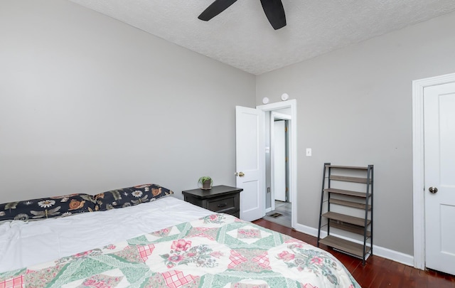 bedroom featuring dark wood-type flooring, a textured ceiling, baseboards, and a ceiling fan