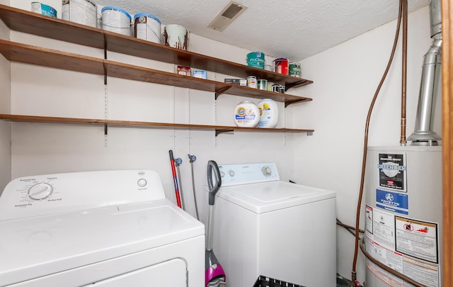 clothes washing area featuring gas water heater, visible vents, a textured ceiling, laundry area, and independent washer and dryer