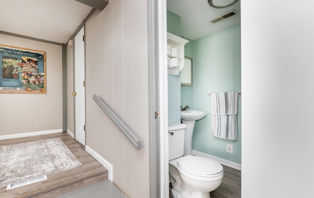 half bathroom featuring toilet, baseboards, visible vents, and wood finished floors