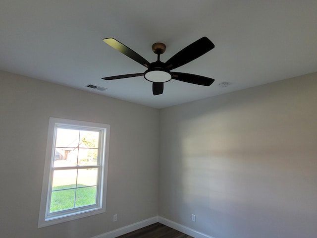 spare room with a ceiling fan, visible vents, and baseboards