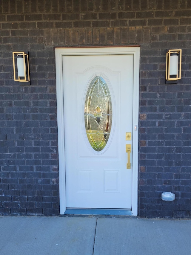 entrance to property featuring brick siding