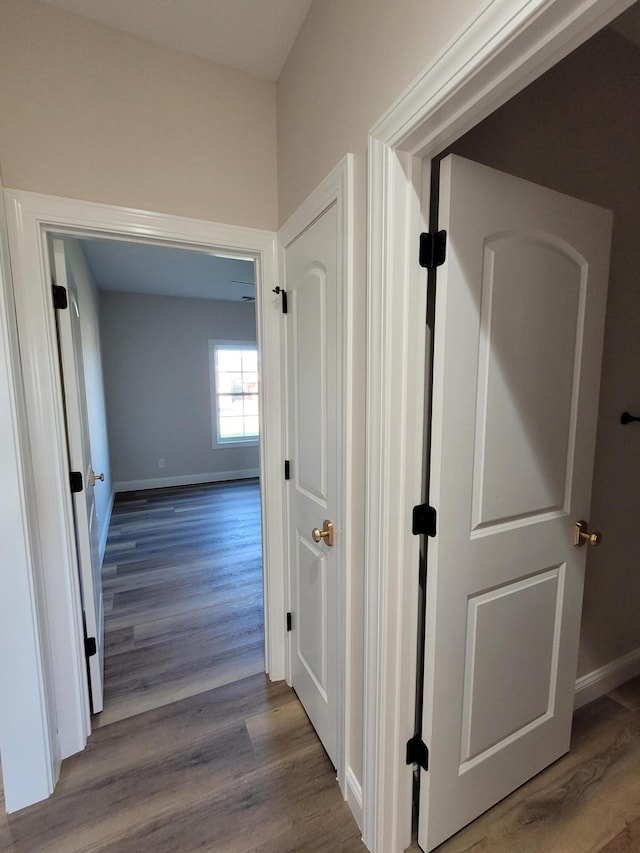 hallway with wood finished floors and baseboards