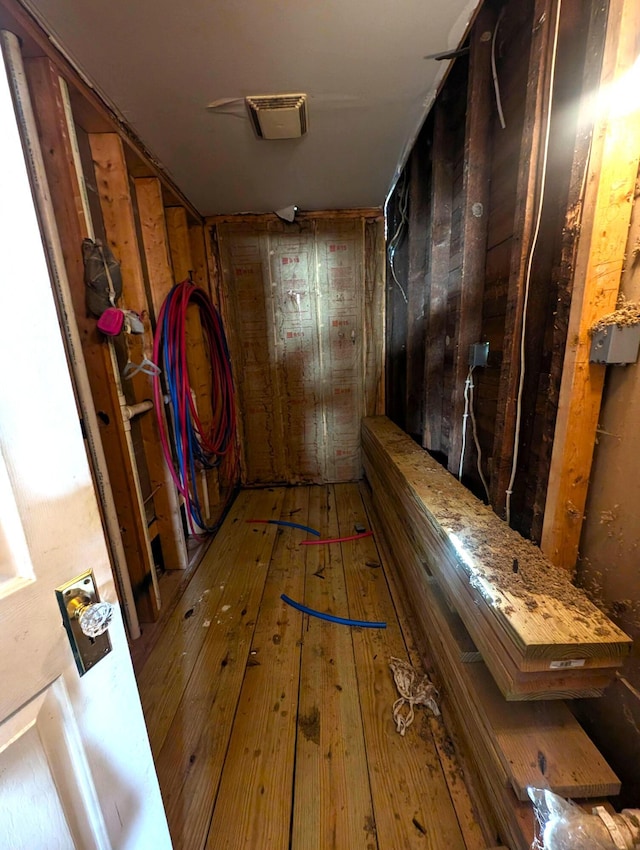 hallway with wood-type flooring and visible vents