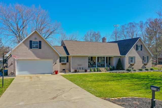 view of front facade with driveway, a chimney, a porch, a front lawn, and brick siding