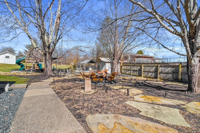 view of yard featuring a playground and fence
