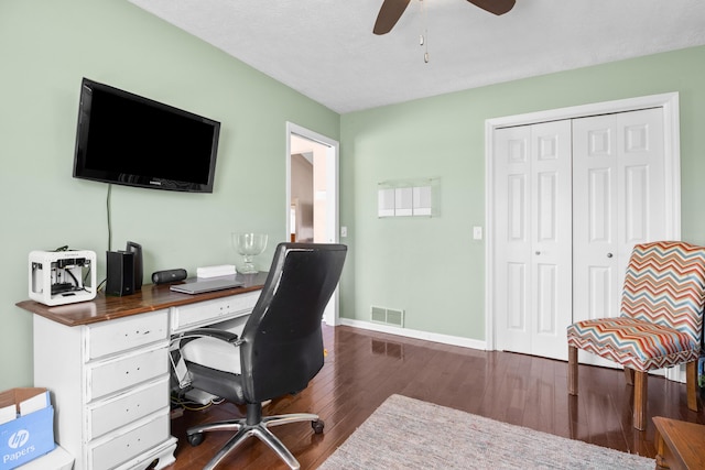office area with dark wood-style floors, a ceiling fan, and baseboards