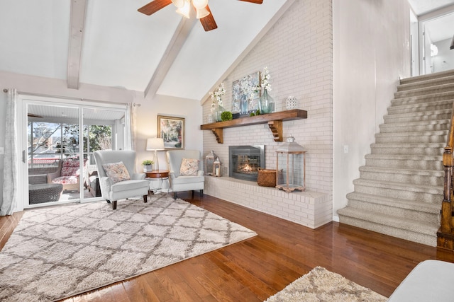 sitting room with wood-type flooring, a ceiling fan, stairway, beamed ceiling, and high vaulted ceiling