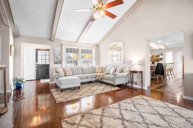 living area featuring hardwood / wood-style floors, beam ceiling, ceiling fan, baseboards, and high vaulted ceiling
