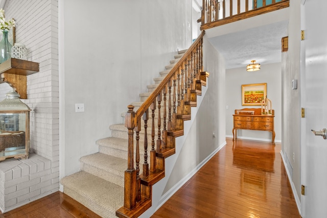staircase with hardwood / wood-style floors and baseboards