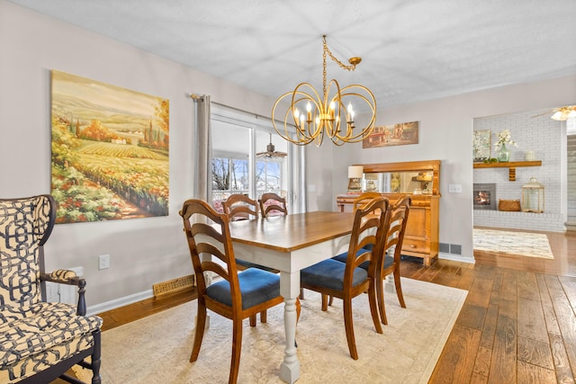 dining area with hardwood / wood-style floors, a chandelier, and baseboards