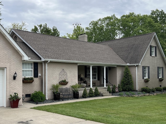 ranch-style house featuring covered porch, brick siding, roof with shingles, and a front yard