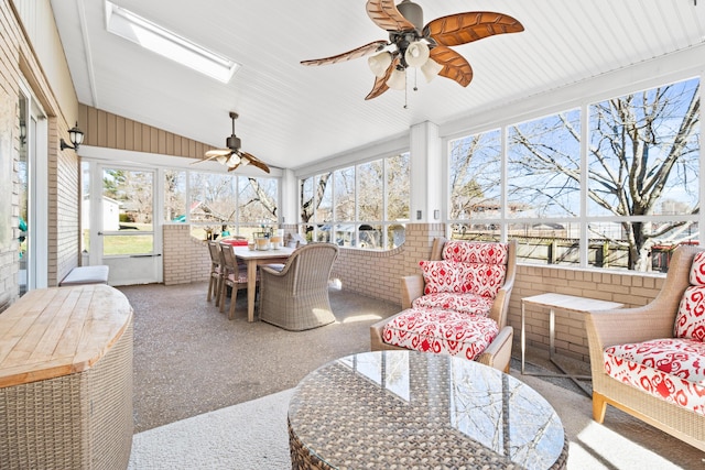 sunroom / solarium featuring outdoor dining area, ceiling fan, vaulted ceiling, and a skylight