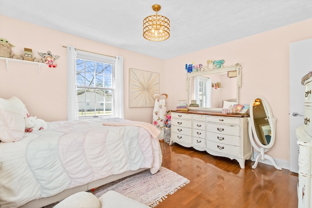 bedroom with wood finished floors and a chandelier