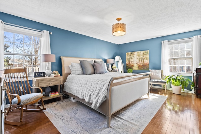 bedroom with hardwood / wood-style floors and a textured ceiling