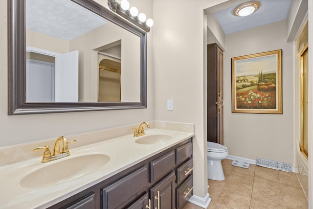 bathroom with toilet, double vanity, baseboards, and tile patterned floors