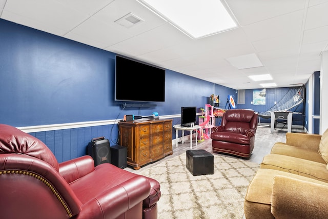 carpeted living room featuring a paneled ceiling and a wainscoted wall