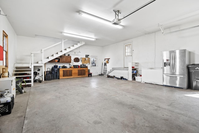 garage with stainless steel fridge, fridge, and a garage door opener