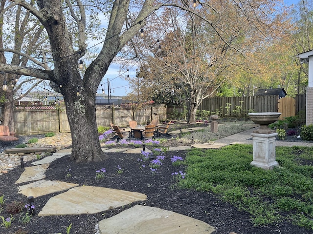 fenced yard featuring an outdoor fire pit and a patio area