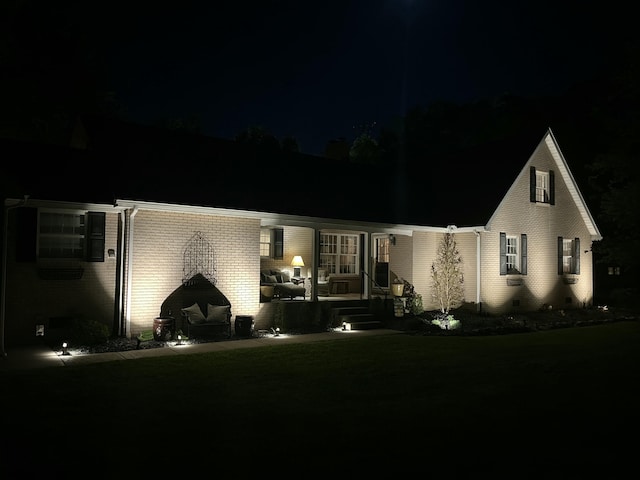 view of front facade featuring brick siding and a yard