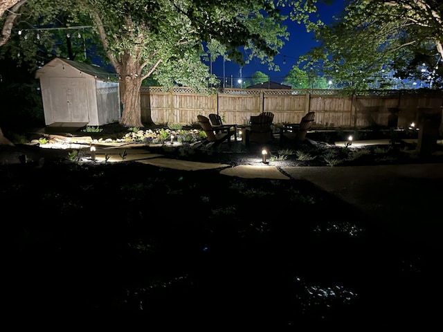 view of yard featuring fence, a storage unit, an outdoor structure, and a patio