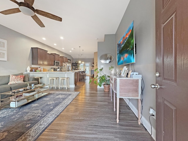 living room featuring recessed lighting, dark wood-style flooring, ceiling fan, and baseboards