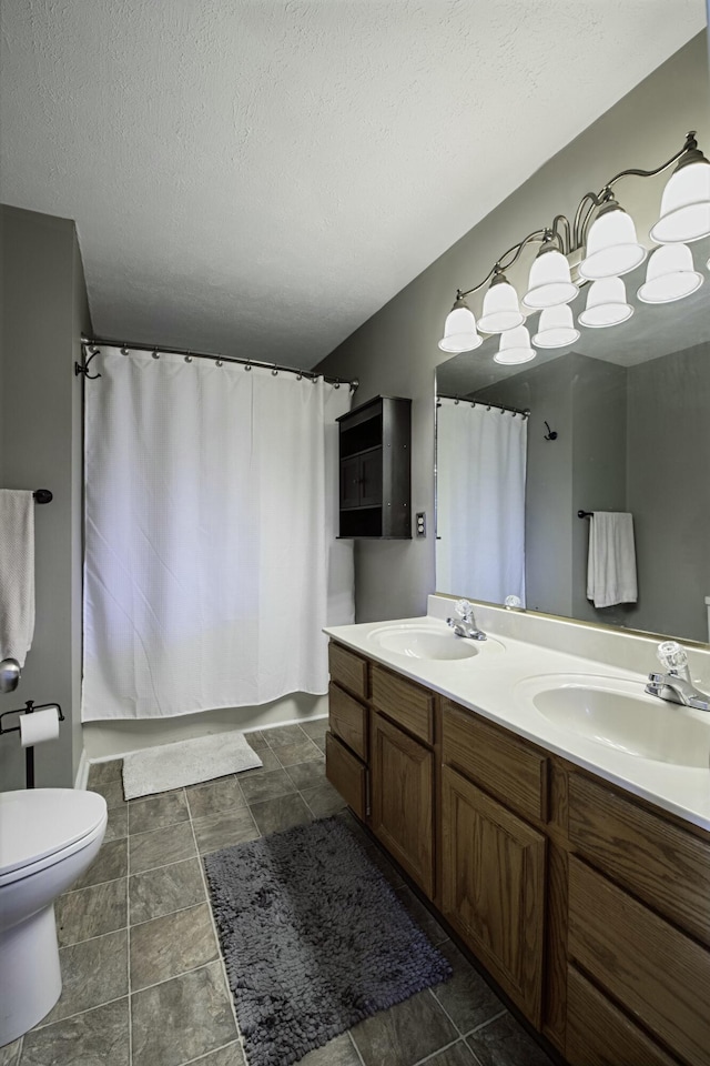 full bathroom featuring toilet, double vanity, shower / bath combo with shower curtain, and a sink