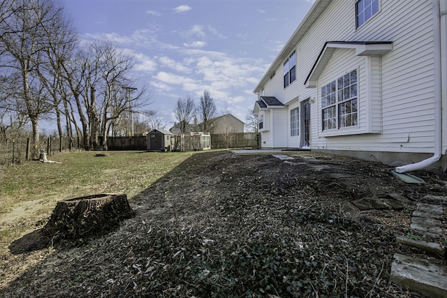 view of yard with an outbuilding, a shed, and fence