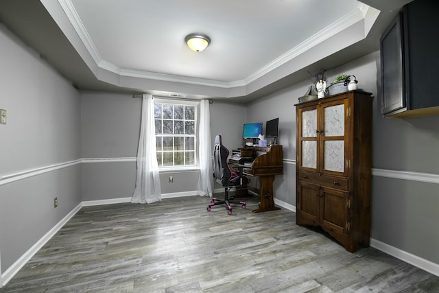 office area featuring ornamental molding, a tray ceiling, and wood finished floors