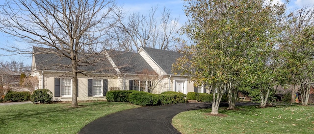 cape cod home with brick siding and a front lawn