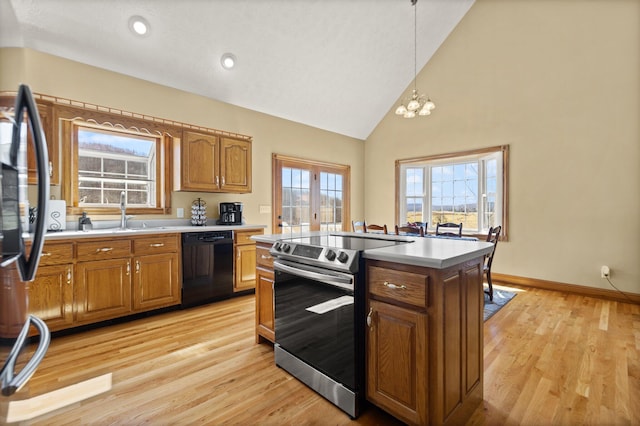 kitchen featuring brown cabinets, black dishwasher, stainless steel range with electric cooktop, and a sink