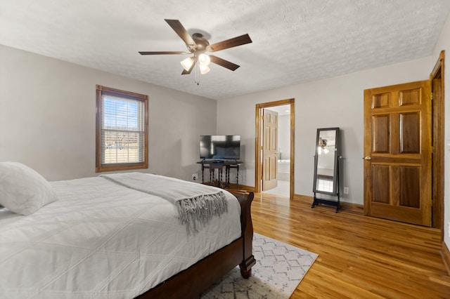 bedroom featuring a textured ceiling, baseboards, a ceiling fan, and light wood-style floors