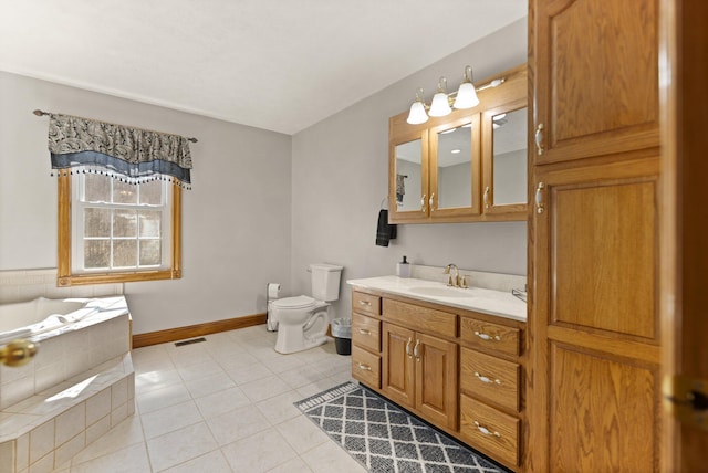 bathroom featuring visible vents, toilet, vanity, tile patterned flooring, and tiled tub